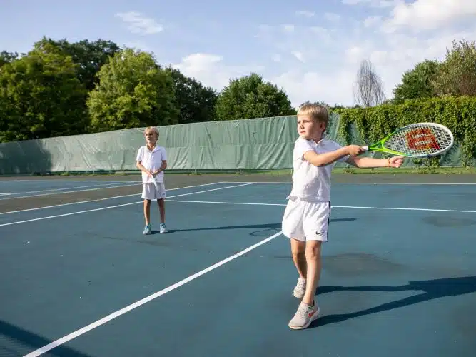 Two kids playing tennis