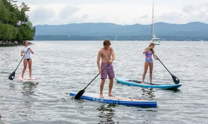 Three high schoolers paddle boarding