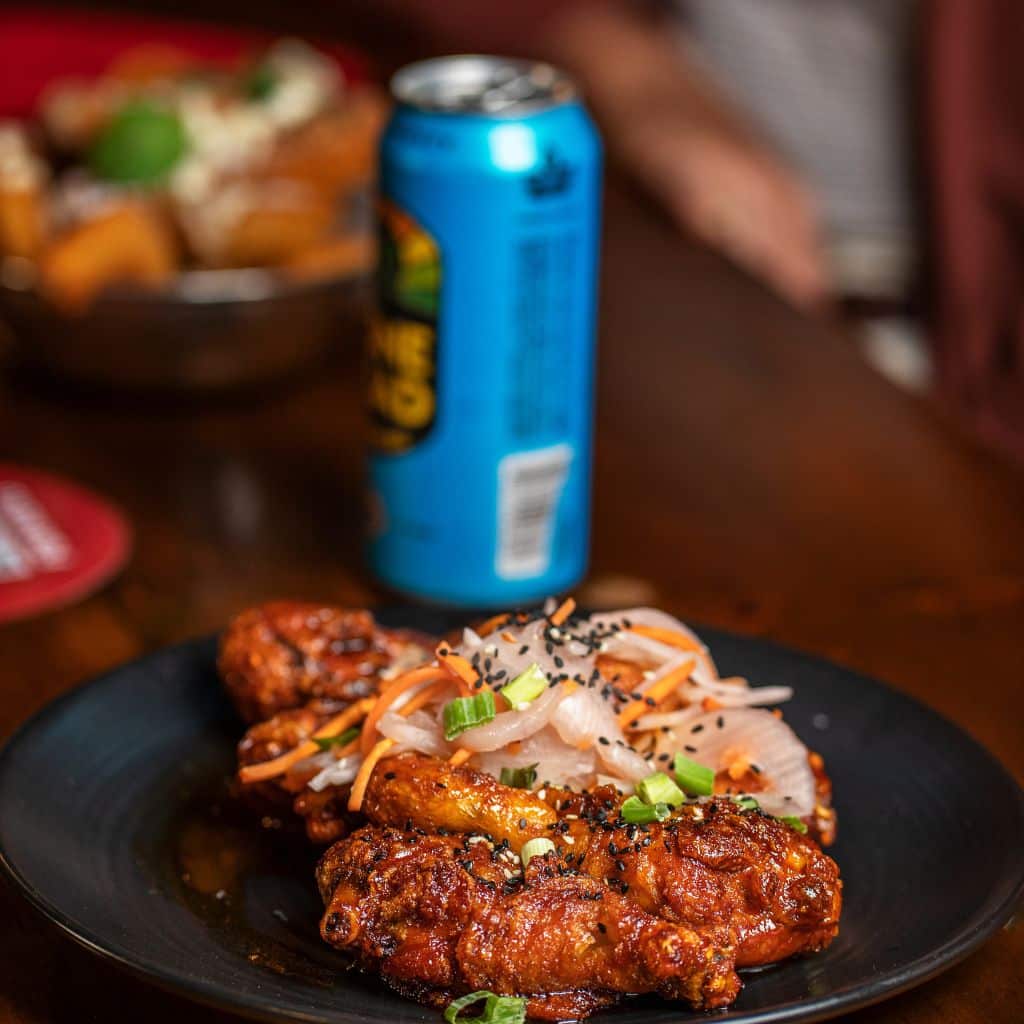 Chicken wings and can of beer on the bar at The REd Mill restaurant