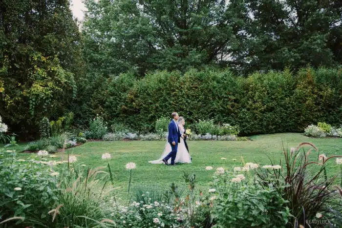 A bride walking down the aisle at the Orchard Garden