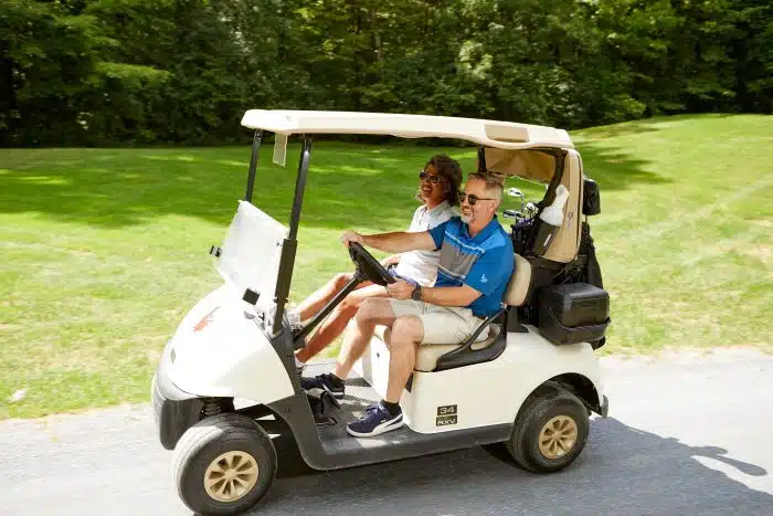 A couple riding in a golf cart