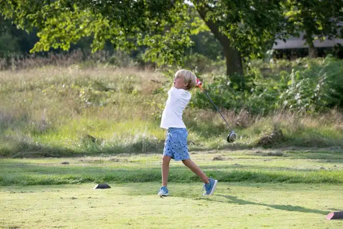 A boy swinging his golf club