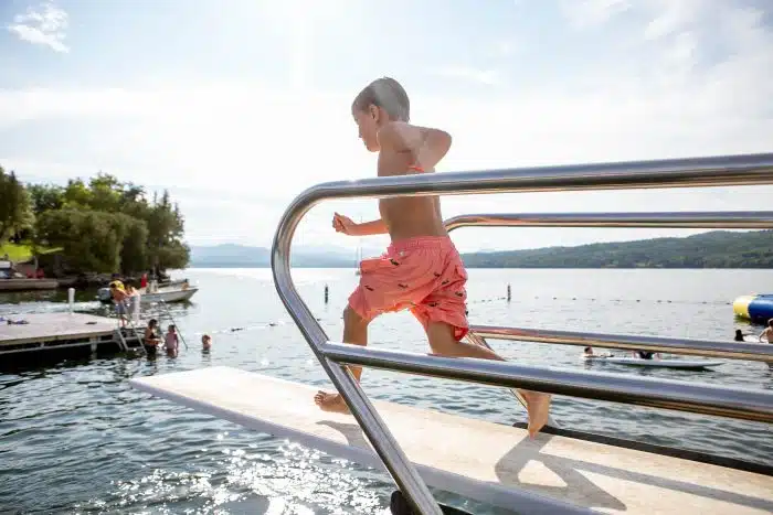 A boy running to jump off a diving board