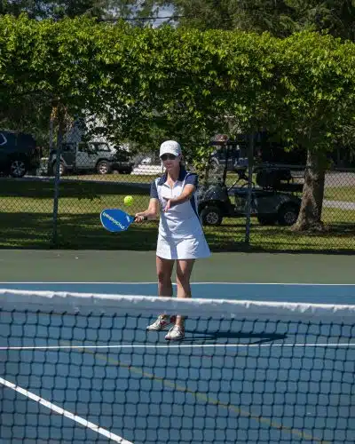 A woman playing pickleball