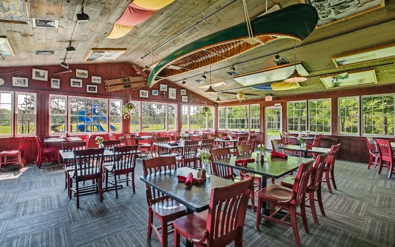 Interior image of the Red Mill deck seating area. Canoe hangs upside-down from the ceiling along with lots of memorabilia and historical photos.