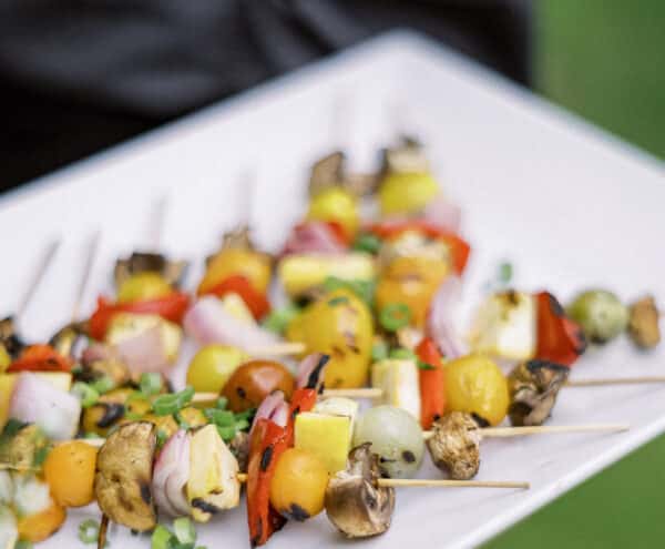 Colorful vegetable skewers being passed around on a tray at a special event