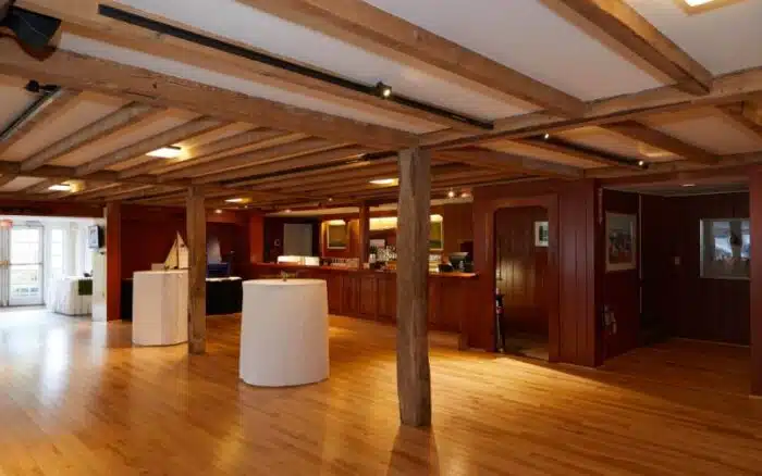 Exposed beams and wooden bar and two hightop cocktail tables