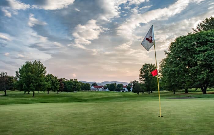 Golf at Basin Harbor. Hole flag sits on a groomed course.