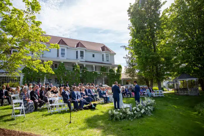 Guests sit in rows witnessing a Lodge Lawn wedding ceremony