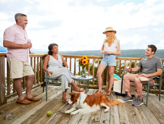 A family on a cottage porch with their dog