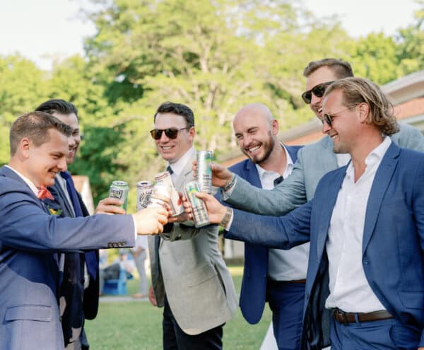 Group of men cheers during a cocktail reception on the Lodge Lawn