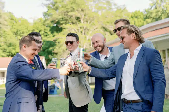 Group of men cheers during a cocktail reception on the Lodge Lawn