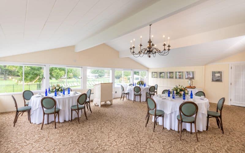 Meeting style tables set at three round tables with podium in the Vermont Room