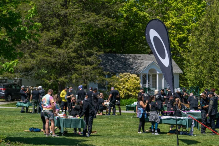 Groups gather around tables for a team building challenge.