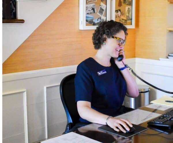 An employee answering the phone at the concierge desk in the lobby of the main lodge