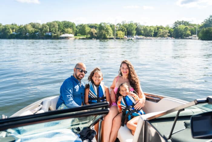 A family sitting in a motorboat, posing for a picture
