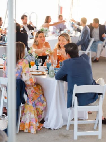 A group seated at a table clinking their glasses.