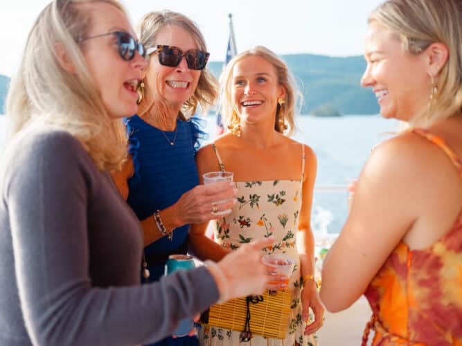 A group of women smiling and laughing while on a boat ride.