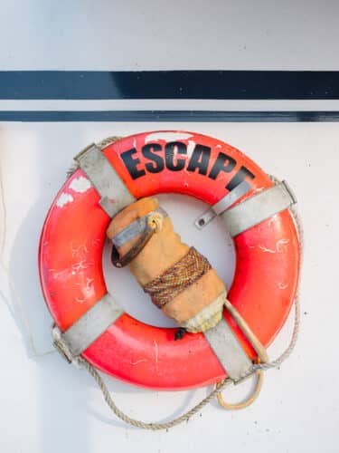 A life preserver on the side of the EScape Cruise boat that reads "ESCAPE"