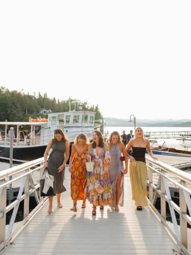 A group of women laughing while walking on the dock ramp back to the beach.